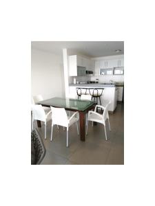 帕拉卡斯Paracas Apartment的厨房以及带桌椅的用餐室。