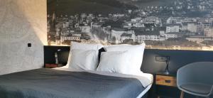 马里博尔Hotel CityMap Maribor的一张带白色枕头的床和一堵城市墙