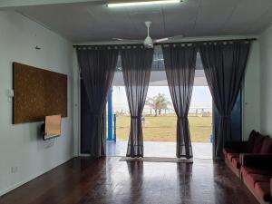 哥打巴鲁ALA Beach Lodge - Ketapang Homestay的客厅设有大窗户和窗帘
