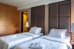 哥打京那巴鲁查亚旅馆的两间相邻的床铺位于酒店客房内