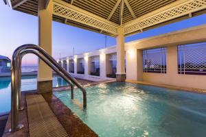 是拉差Classic Kameo Hotel and Serviced Apartments, Sriracha的一座大楼内带水滑梯的游泳池