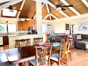 科纳Ocean Breeze Kona Home的厨房以及带木桌和椅子的客厅。