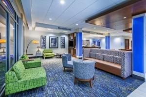 OwassoHoliday Inn Express & Suites - Tulsa Northeast - Owasso, an IHG Hotel的酒店大堂设有绿色椅子和沙发