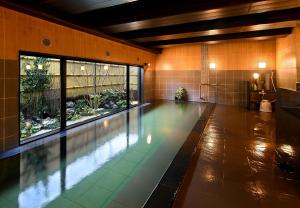 千曲市HOTEL ROUTE-INN Kamiyamada Onsen的一座带大窗户的建筑中的游泳池