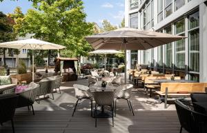 慕尼黑慕尼黑施泰根博阁酒店的一个带桌椅和遮阳伞的庭院