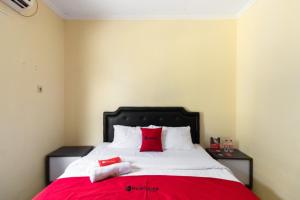 日惹RedDoorz @ Raya Janti Yogyakarta的一间卧室配有一张带红色枕头的大床