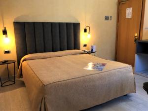 维亚雷焦蒂雷尼亚酒店的一间卧室配有一张大床和大床头板
