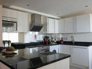 波特兰Panoramic View的厨房配有白色橱柜和黑色台面