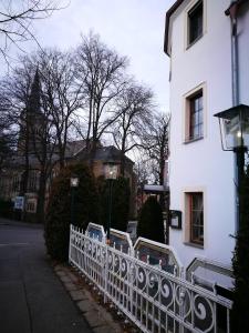 开姆尼茨Pension & Gasthaus Nostalgie的一座白色的建筑,在建筑物旁边设有白色的围栏