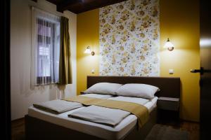 莫劳豪洛姆Németh Apartmanházak的一间卧室设有一张黄色墙壁和窗户的床