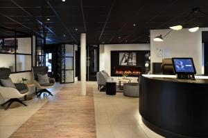 阿姆斯特丹Gr8 Hotel Amsterdam Riverside的大堂设有酒吧、椅子和壁炉