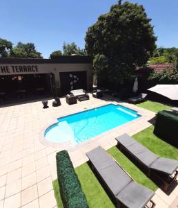 布里茨Palm Swift Luxury Accommodation的一个带躺椅的庭院内的游泳池