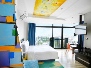 芭堤雅市中心Siam@Siam Design Hotel Pattaya的一间卧室配有一张床、一张书桌和一台电视
