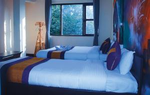 加德满都Rest Up Kathmandu Hostel的两张位于酒店客房的床,配有两张sidx sidx单人床