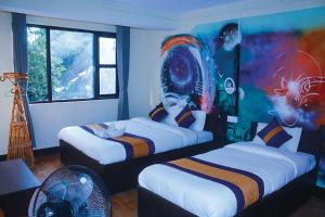 加德满都Rest Up Kathmandu Hostel的一间设有两张床的客房,墙上挂着一幅画