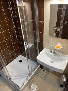 科希策运动旅馆的带淋浴和盥洗盆的浴室
