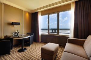 海滨诺德韦克Grand Hotel Huis ter Duin的酒店客房设有桌子和窗户。
