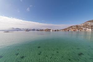 索玛若伊Sommarøy Arctic Hotel Tromsø的一大片水体,背景是群山