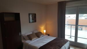 马赛普罗旺斯公寓酒店的一间卧室设有一张床和一个大窗户