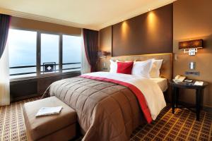 海滨诺德韦克Grand Hotel Huis ter Duin的一间设有大床和窗户的酒店客房