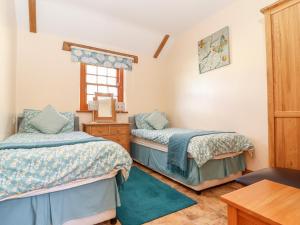 赫尔斯顿Valley View的一间卧室设有两张床和窗户。