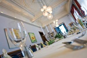 布伦瑞克德意志豪斯酒店的一间带桌椅和吊灯的用餐室