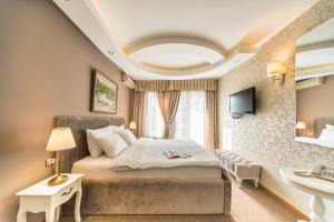 克拉古耶瓦茨Garni Hotel President de Luxe的一间卧室设有一张大床和一个水槽