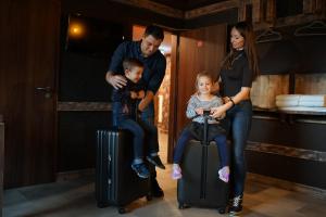 科隆Aparthotel MyCologne的一个有两个孩子坐在手提箱上的家庭