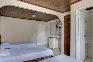 伊帕廷加Hotel Estrela Do Vale的一间带两张单人床的卧室和一间浴室