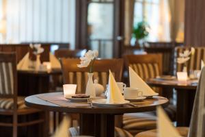 普雷罗斯坦德克咖啡厅酒店的餐厅里摆放着一盘带菜和鲜花的桌子