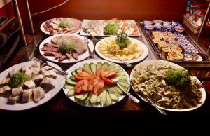 Malnia林德酒店的一张桌子上放着许多盘子的食物