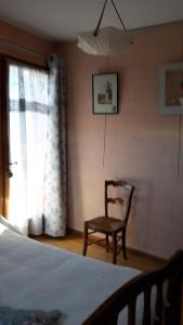 Saint-PancraceChambre d'hôtes - La Maurillonnette的卧室配有床、椅子和窗户。