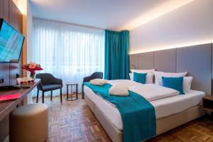 巴特苏尔察Hotel an der Therme Bad Sulza的酒店客房设有一张大床和一张书桌。