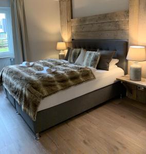 哈嫩克利博克斯维斯ferienapartment hahnenklee Apart 1的一间卧室配有一张大床和木制床头板