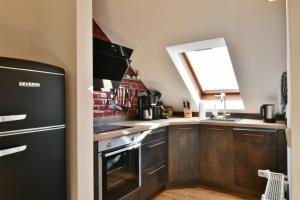 维林根Fewo Blumes Bergfrieden mit MeineCardPlus的厨房配有黑色冰箱和窗户。