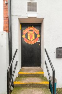 曼彻斯特Old Trafford Stadium Hotel的黑色的门,上面有读哈佛大学的标志