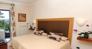圣达塞拉金塔大科瓦多米尔霍酒店的一间卧室配有一张带大床头板的床