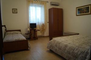 阿尔贝罗贝洛卡萨德尔诺诺旅馆的一间卧室配有两张床和电视。