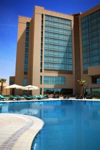 埃尔比勒Erbil Rotana的大楼前设有游泳池的酒店