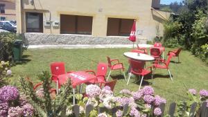 科隆布雷斯Apartamento el Peral A的院子里一群红色的椅子和一张桌子