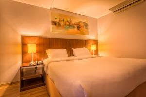 圣保罗H3 Hotel Paulista的卧室配有一张白色的大床和床头柜。