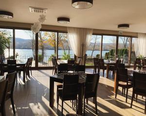 Radvaň nad DunajomMlyn Penzion & Wellness的一间带桌椅并享有水景的餐厅