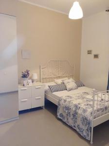 加的斯加的斯旅馆的卧室配有白色的床、床头柜和西德西德克斯床