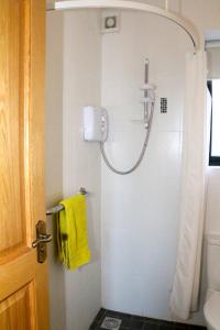 莫纳汉Emy Lake Apartment - near Castle Leslie, Glaslough的一间带黄色毛巾淋浴的浴室