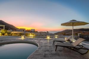 加里尼Naxos Secret Paradise Villa的一个带2把躺椅和遮阳伞的游泳池