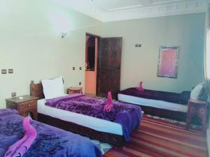 伊姆利尔Atlas Imoula的一间卧室配有两张床,上面有粉红色的火烈鸟