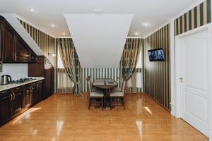 苏梅City Center Apart-Hotel的铺有木地板,设有带桌椅的厨房。