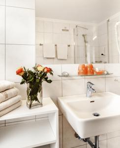 魏森湖Kraners Alpenhof BIO Bed and Breakfast Pension的白色的浴室设有水槽和花瓶