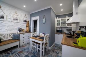 布拉迪斯拉发Apartman Sv. Urban的厨房配有白色橱柜、桌子和柜台。
