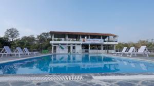 BardiyāBabai Resort Pvt Ltd的一座带椅子的大型游泳池和一座建筑